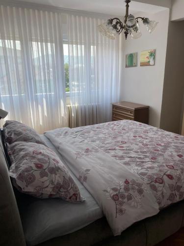 a bedroom with a bed and a window with curtains at Apartman Filip Lux City Center in Novi Pazar
