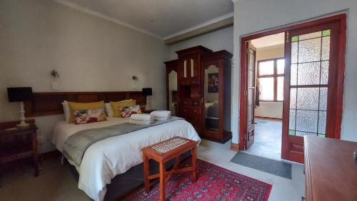 a bedroom with a bed and a table in it at Bluebell Barn in Dullstroom