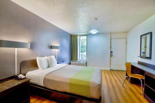Habitación de hotel con cama, escritorio y ventana en Motel 6-Gainesville, FL, en Gainesville