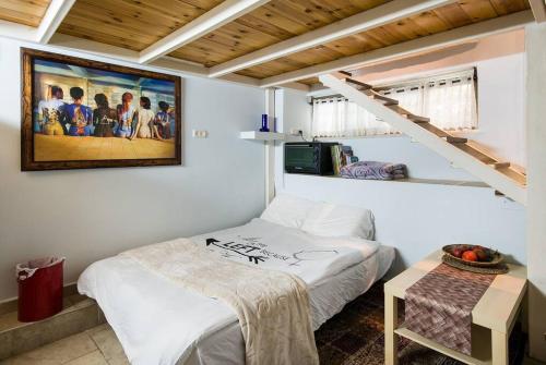 Habitación con cama y una foto en la pared. en Ahuzat Shaul - Apartment, en H̱adera