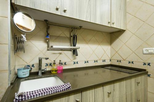 a kitchen counter with a sink and a mirror at Ahuzat Shaul - Apartment in H̱adera