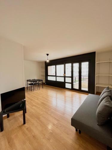 een woonkamer met een bank en een tafel bij PoNSARDIN - Bel appartement avec balcon et Parking in Reims