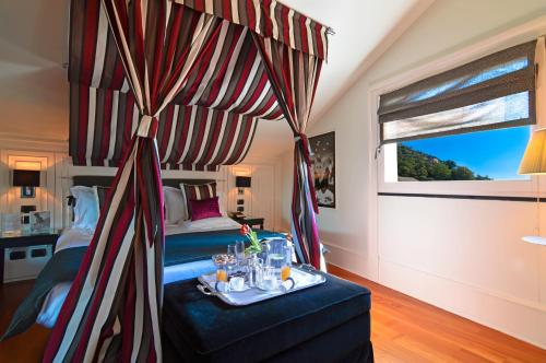 a bedroom with a bed and a table with a tray of drinks at Eight Hotel Portofino in Portofino