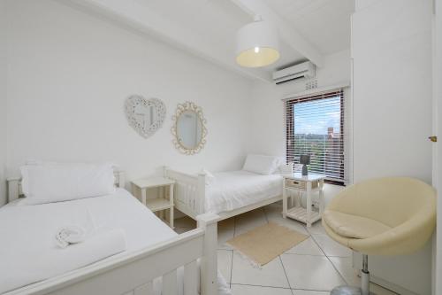 a white room with a bed and a chair at San Lameer Villa 2832 - 3 Bedroom Classic - 6 pax - San Lameer Rental Agency in Southbroom