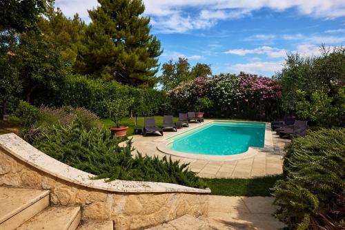 una piscina in un cortile con sedie intorno di Villa Roberta - Homelike Villas a Fano