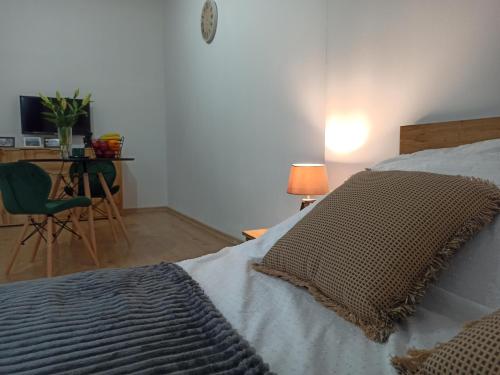 a bedroom with a bed and a table and a chair at Cztery Kąty w Rynku in Wałbrzych