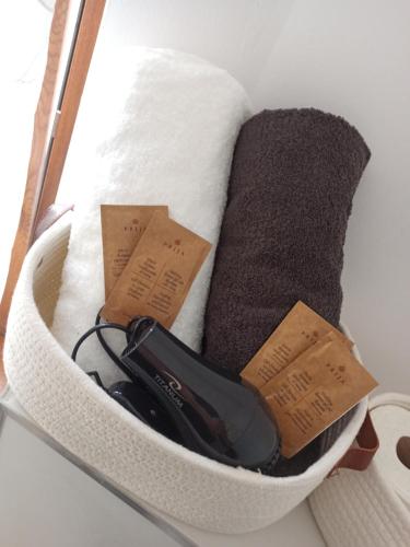 a white basket with a hair dryer and towels at Cztery Kąty w Rynku in Wałbrzych