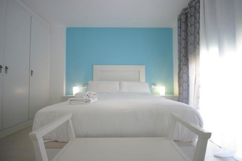 een witte slaapkamer met een wit bed en een raam bij Livingtarifa Sugar in Tarifa