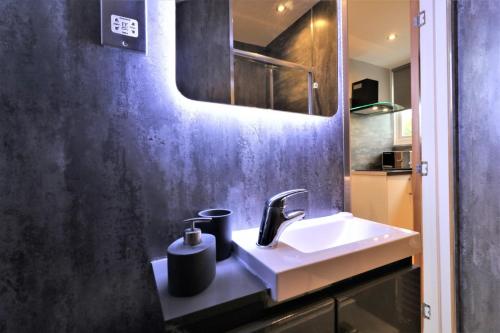 ein Bad mit einem Waschbecken und einem Spiegel in der Unterkunft Signature - Linden Cottage Room 4 in Airdrie