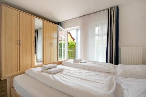 a bedroom with a large white bed with towels on it at Villa Karina by Rujana in Göhren