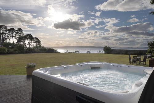 a jacuzzi tub on a patio with a view of the ocean at Golf View Hotel & Spa in Nairn