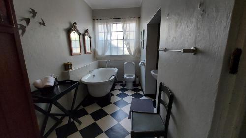 a bathroom with a tub and a toilet and a sink at Bluebell Country House in Dullstroom