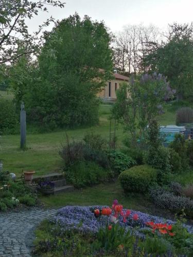 a garden with flowers and a house in the background at Waldheimat in Miltach
