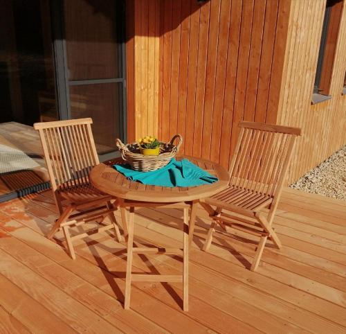 a table with two chairs and a bowl of fruit at Waldheimat in Miltach