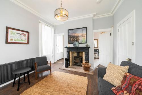 a living room with a couch and a fireplace at The Gate Lodge in Broughty Ferry