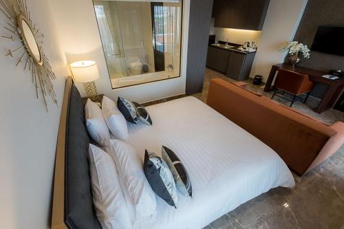 a bedroom with a large white bed with pillows at SN Connx - SHA Plus in Pattaya Central