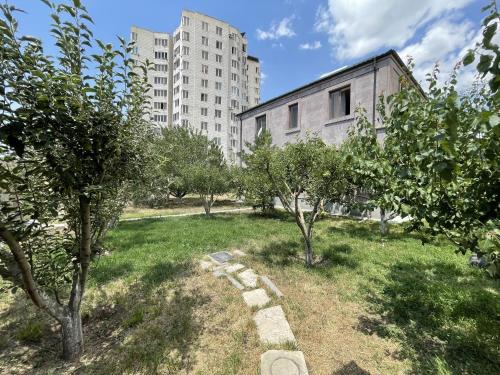 a garden with trees in front of a building at Yerevan Villa with all modern conveniences in Yerevan
