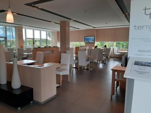 a restaurant with white tables and white chairs at Hotel Sercotel Plana Parc in Alquerías del Niño Perdido