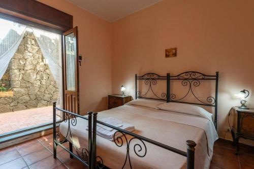 a bedroom with a bed and a large window at Biologico Dell'Etna in Trecastagni