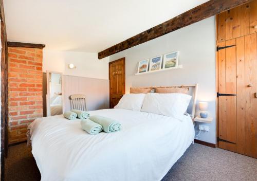 a bedroom with a large white bed with towels on it at The Anchorage in Sheringham