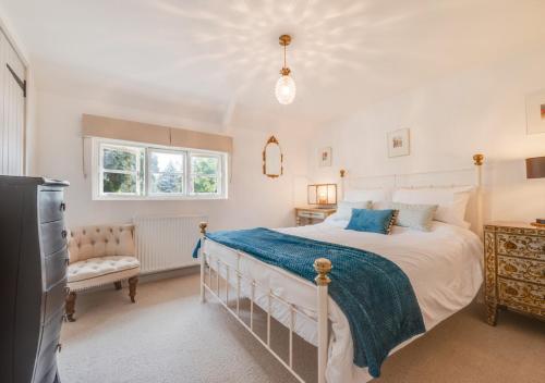 a bedroom with a large bed and a television at Pineapple Cottage in Holt