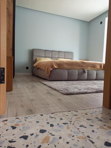 a bedroom with a bed and a rug on a floor at NEW apartment for RELAX in Uzhhorod