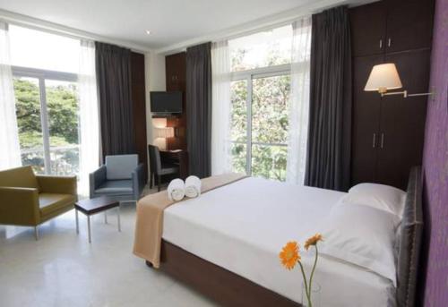 a bedroom with a large white bed with two towels on it at The Park Slope Hotel in Bangalore