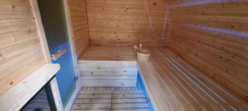 an empty wooden sauna with a bucket in it at Elitní wellness penzion U Dvou jedlí v srdci Českého ráje in Turnov