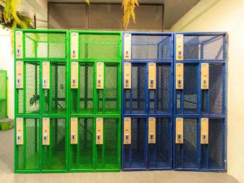a row of green lockers in a room at Khao San Social Capsule Hostel in Bangkok