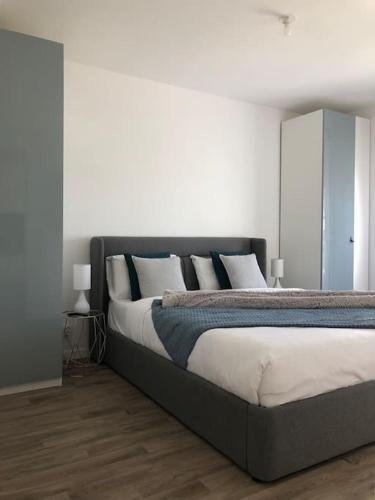 - une chambre avec un grand lit aux murs blancs dans l'établissement ***Suite Parklane* 5min Disney & Shopping * NEW***, à Serris