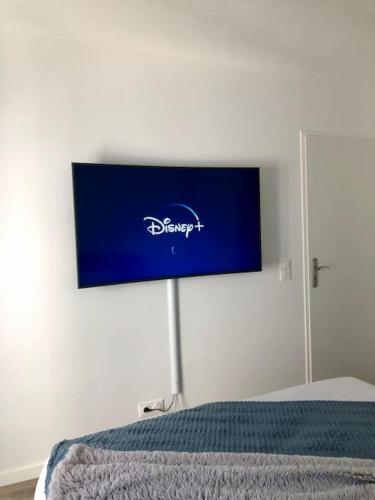 un panneau bleu sur un mur au-dessus d'un lit dans l'établissement ***Suite Parklane* 5min Disney & Shopping * NEW***, à Serris