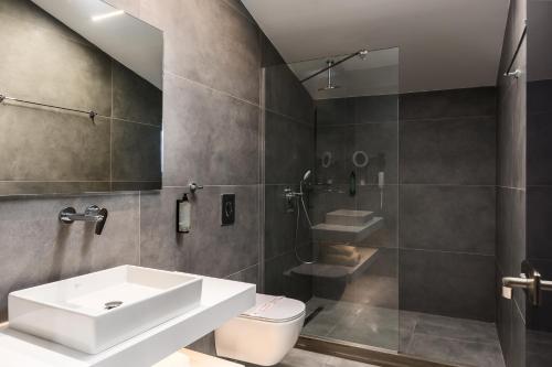 a bathroom with a sink and a toilet and a shower at Acharavi Beach Hotel in Acharavi
