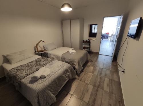 um quarto de hotel com duas camas e uma televisão em LAVALLE 80 - CORRIENTES - A PASOS DE PLAYA Y COSTANERA em Corrientes
