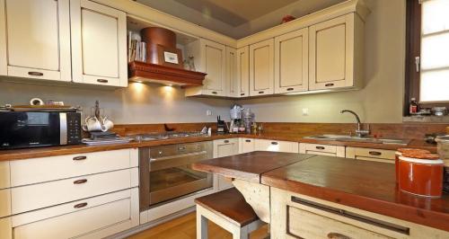 a kitchen with white cabinets and a wooden counter top at Plethora Arachova Luxury Chalet in Arachova
