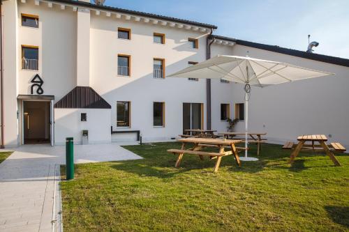 a building with a picnic table and an umbrella at Nomad Hostel in Treviso