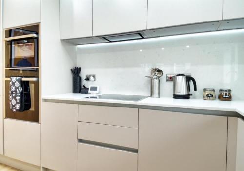 a kitchen with white cabinets and a sink at Green Mews 3 with Free Parking - By My Getaways in Brighton & Hove