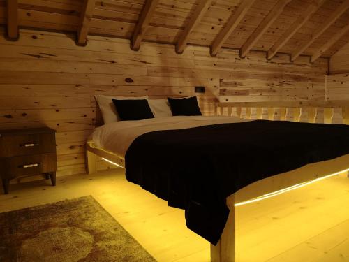 1 dormitorio con 1 cama en una cabaña de madera en LİMCORA DAĞEVLERİ&BUNGALOW, en Rize