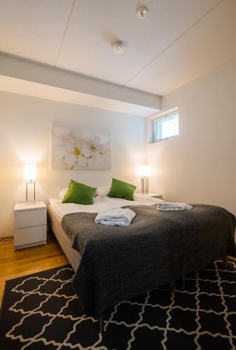 a bedroom with a large bed with two green pillows at Finlandia Hotel Aquarius in Uusikaupunki