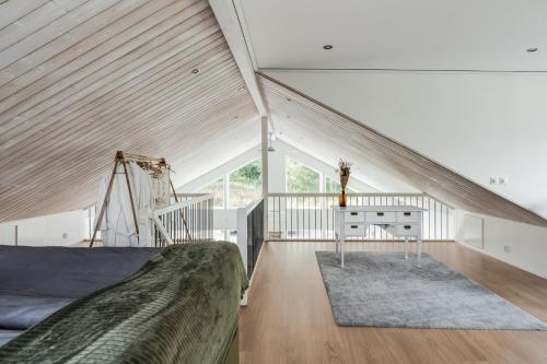 Dormitorio en el ático con cama y escritorio en Luxury holiday home in Tallbacken with lake views over Bolmen en Ljungby