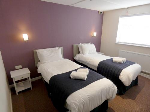 a hotel room with two beds and a window at The Riverside Hotel in Monmouth