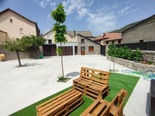 un par de bancos de madera sentados en un patio en CASA PESCA VERA, en Senegüé