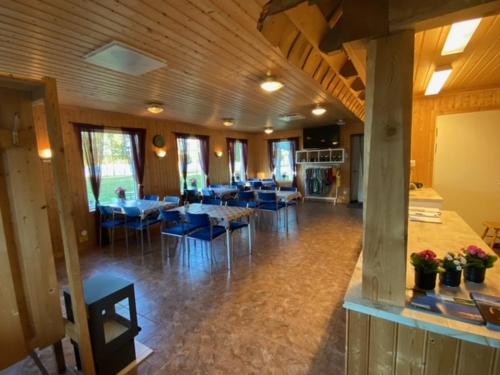 Fredrika的住宿－Camping Fredrika-Braber，一间在房间内配有桌子和蓝色椅子的餐厅