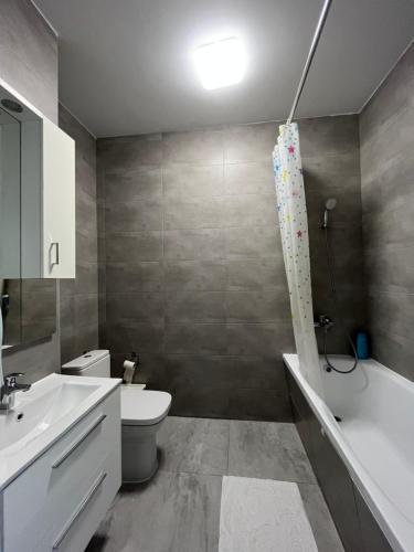 a bathroom with a toilet and a tub and a sink at airport comfy guest home in Warsaw