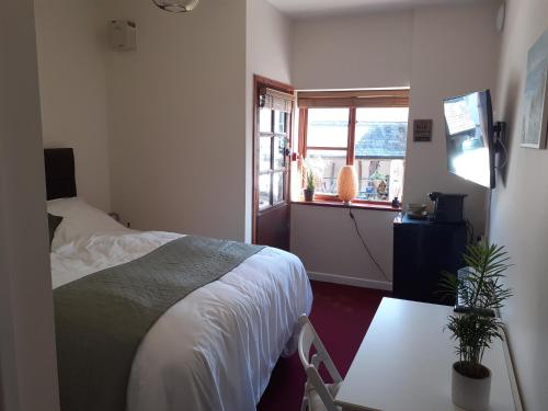 a bedroom with a bed and a window at The Ivy Barn Holbeton in Plymouth