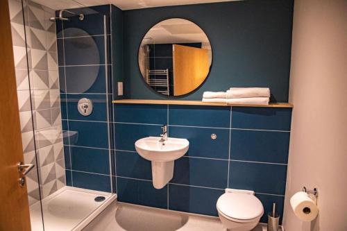 a bathroom with a sink and a toilet and a mirror at The Lake House in Liverpool