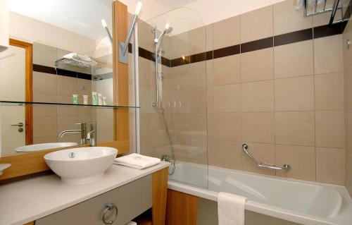 La salle de bains est pourvue d'une baignoire, d'un lavabo et d'une douche. dans l'établissement travelski home premium - Résidence Edenarc 5 stars, à Arc 1800