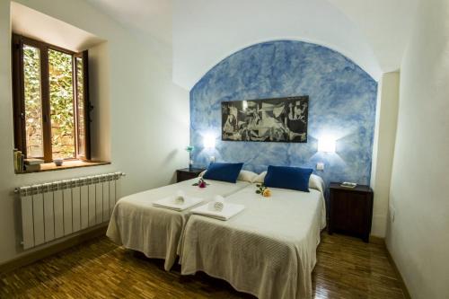 1 dormitorio con 1 cama con pared azul en La Posada de Grimaldo, en Grimaldo