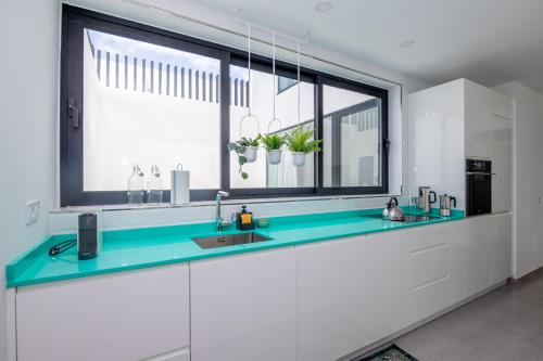 a kitchen with a sink and a large window at Cascasas The Green Apartment in Corralejo