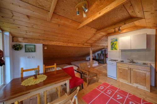 a kitchen and living room with a wooden ceiling at Cottage surrounded by forests - The Sunny Hill 