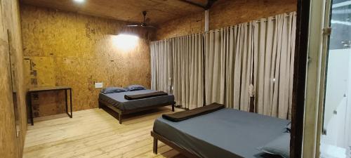 a room with two beds and a fireplace in it at The Tribe Agrotourism, Wai mahabaleshwar in Panchgani